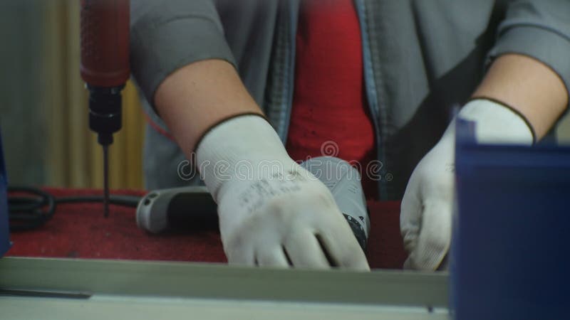 Ο εργαζόμενος κινηματογραφήσεων σε πρώτο πλάνο στα γάντια συγκεντρώνει το τρυπάνι με τις λεπτομέρειες απόθεμα βίντεο
