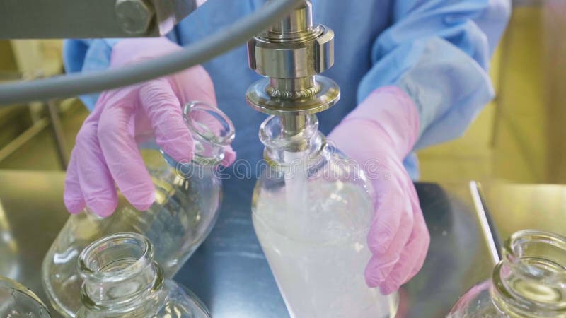 Ο εργαζόμενος χύνει το υγρό στα capacites στο χημικό εργαστήριο απόθεμα βίντεο