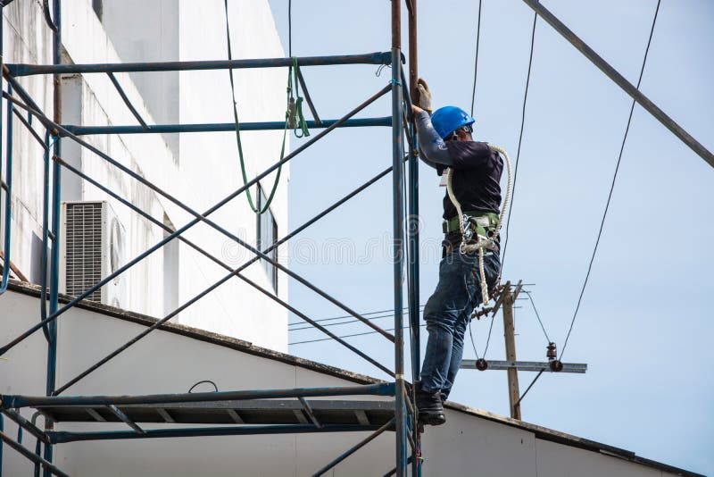 Ο ηλεκτρολόγος εργάζεται στα υλικά σκαλωσιάς υπαίθρια στοκ φωτογραφίες Ο ηλεκτρολόγος εργάζεται στα υλικά σκαλωσιάς υπαίθρια στοκ φωτογραφίες