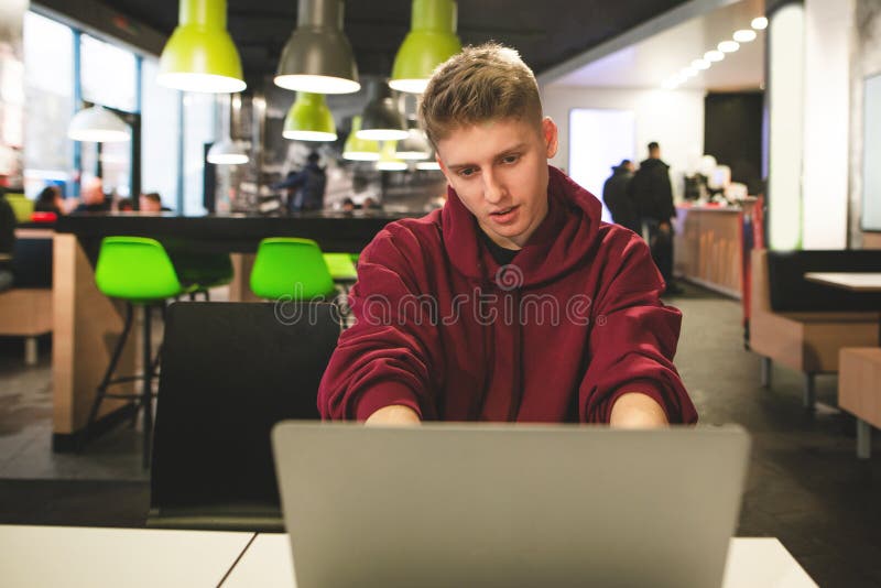 Ο θετικός τύπος λειτουργεί σε ένα lap-top στο υπόβαθρο του εστιατορίου Ευτυχείς εργασίες σπουδαστών στοκ φωτογραφίες με δικαίωμα ελεύθερης χρήσης Ο θετικός τύπος λειτουργεί σε ένα lap-top στο υπόβαθρο του εστιατορίου Ευτυχείς εργασίες σπουδαστών στοκ φωτογραφίες με δικαίωμα ελεύθερης χρήσης