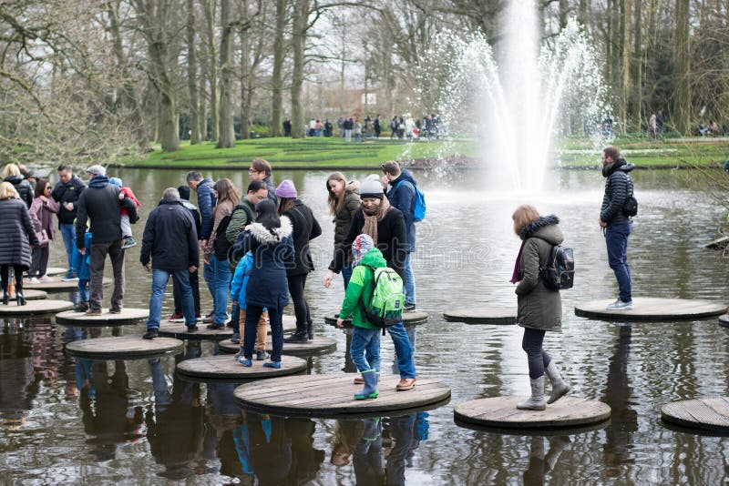 Ο κήπος Keukenhof, άνθρωποι διασχίζει τη λίμνη στοκ φωτογραφίες Ο κήπος Keukenhof, άνθρωποι διασχίζει τη λίμνη στοκ φωτογραφίες