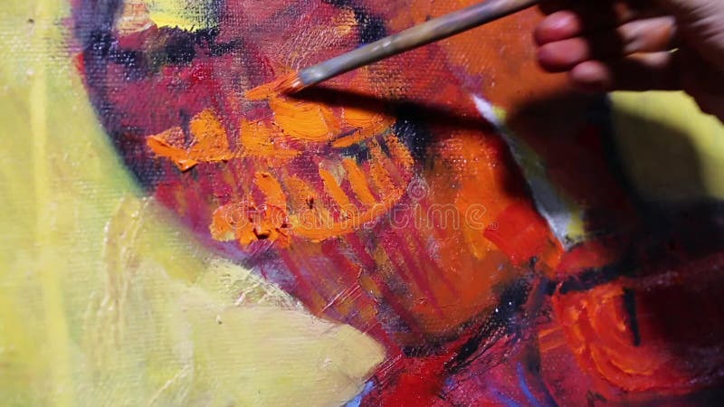 Ο καλλιτέχνης χρωματίζει μια ζωγραφική στον καμβά