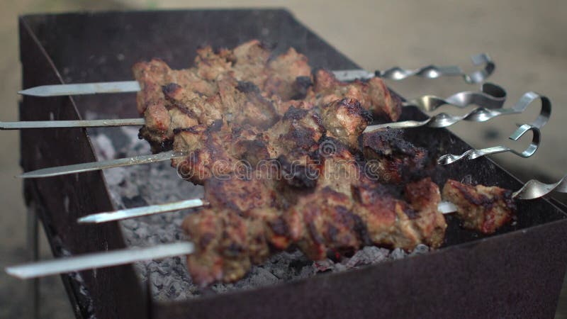 Ο μάγειρας παίρνει ένα έτοιμο shish kebab από τη σχάρα στα οβελίδια για τους πελάτες