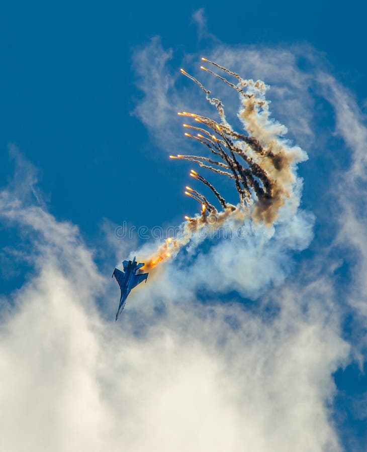 Ο μαχητής SU-27 στρατιωτικού αεροπλάνου μύτη-κατάδυση, εκτελεί τον ελιγμό με την εκτίναξη των βλημάτων θερμότητας στοκ εικόνες Ο μαχητής SU-27 στρατιωτικού αεροπλάνου μύτη-κατάδυση, εκτελεί τον ελιγμό με την εκτίναξη των βλημάτων θερμότητας στοκ εικόνες