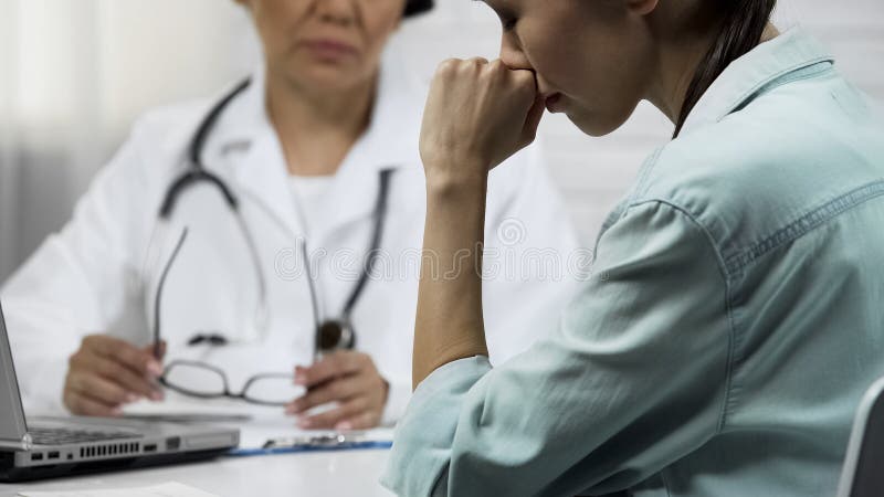 Ο νέος ασθενής ανακαλύπτει για τη αθεράπευτη ασθένεια, θηλυκός γιατρός που λέει τις κακές ειδήσεις στοκ εικόνα με δικαίωμα ελεύθερης χρήσης Ο νέος ασθενής ανακαλύπτει για τη αθεράπευτη ασθένεια, θηλυκός γιατρός που λέει τις κακές ειδήσεις στοκ εικόνα με δικαίωμα ελεύθερης χρήσης