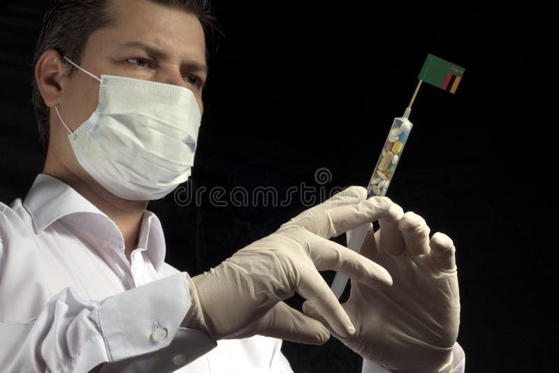 Ο νεαρός άνδρας ως γιατρός δίνει μια ιατρική έγχυση στην της Ζάμπια σημαία στοκ φωτογραφία
