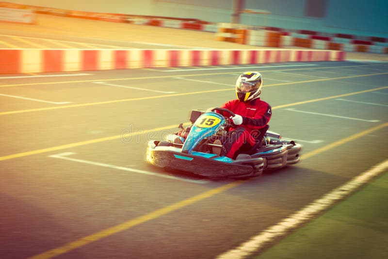 Ο νεαρός άνδρας οδηγεί πηγαίνει -πηγαίνω-kart αυτοκίνητο με την ταχύτητα σε μια διαδρομή αγώνα παιδικών χαρών στοκ εικόνα Ο νεαρός άνδρας οδηγεί πηγαίνει -πηγαίνω-kart αυτοκίνητο με την ταχύτητα σε μια διαδρομή αγώνα παιδικών χαρών στοκ εικόνα