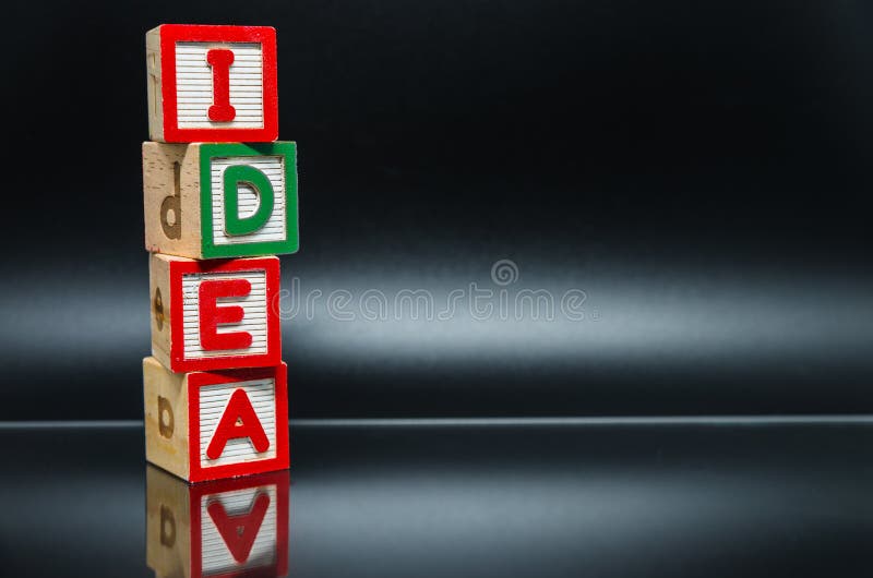 Ο ξύλινος φραγμός λέξης του cIdea τακτοποιεί στο κάθετο ύφος στο μαύρο υπόβαθρο και την εκλεκτική εστίαση στοκ εικόνες