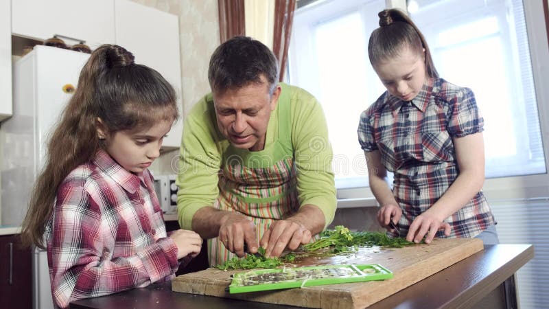 Ο πατέρας παρουσιάζει προσεκτικές κόρες που κόβουν τα πράσινα εν πλω