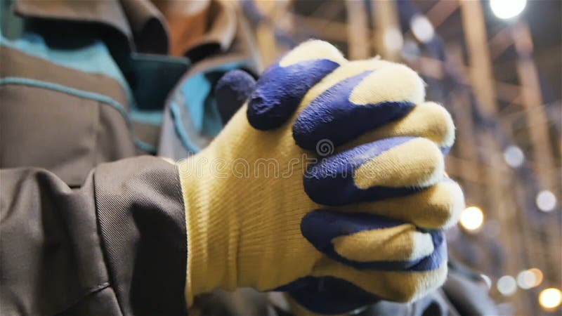 Ο σε αργή κίνηση εργαζόμενος κινηματογραφήσεων σε πρώτο πλάνο στα γάντια χτυπά τα χέρια του απόθεμα βίντεο