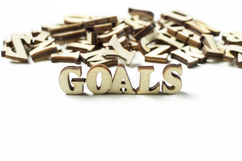 The word goal written in wooden letters, the concept of setting goals. The word goal written in wooden letters, the concept of setting goals.