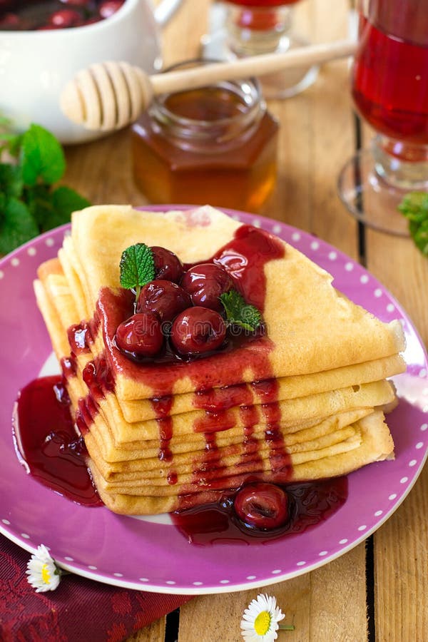 Ο σωρός λεπτού crepes με το κάλυμμα κερασιών στοκ εικόνα με δικαίωμα ελεύθερης χρήσης Ο σωρός λεπτού crepes με το κάλυμμα κερασιών στοκ εικόνα με δικαίωμα ελεύθερης χρήσης