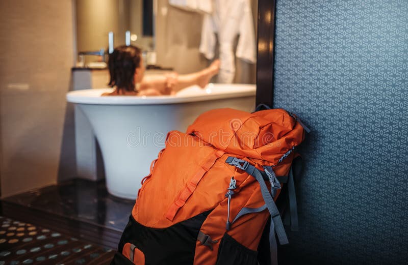 Ο ταξιδιώτης γυναικών backpacker παίρνει ένα λουτρό μέσα υψηλό - ποιοτικό ξενοδοχείο στοκ φωτογραφία