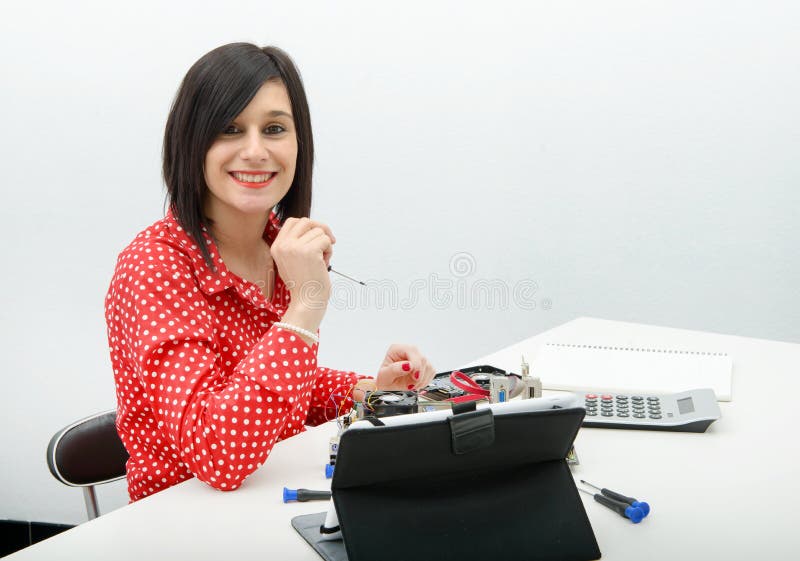 Ο τεχνικός γυναικών Brunette επισκευάζει έναν υπολογιστή στοκ φωτογραφία με δικαίωμα ελεύθερης χρήσης Ο τεχνικός γυναικών Brunette επισκευάζει έναν υπολογιστή στοκ φωτογραφία με δικαίωμα ελεύθερης χρήσης
