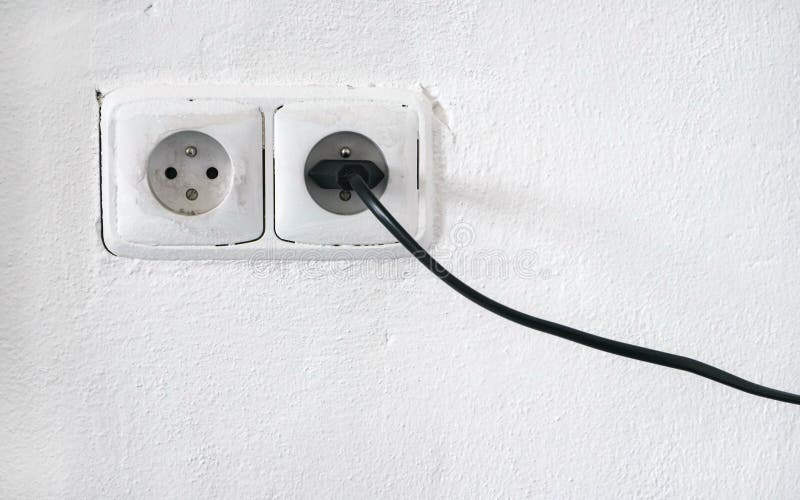 Ο τραχύς άσπρος τοίχος προσόψεων με δύο ευρωπαϊκή έξοδο δύναμης ύφους, μια υποδοχή σύνδεσε το μαύρο καλώδιο στοκ φωτογραφίες με δικαίωμα ελεύθερης χρήσης Ο τραχύς άσπρος τοίχος προσόψεων με δύο ευρωπαϊκή έξοδο δύναμης ύφους, μια υποδοχή σύνδεσε το μαύρο καλώδιο στοκ φωτογραφίες με δικαίωμα ελεύθερης χρήσης