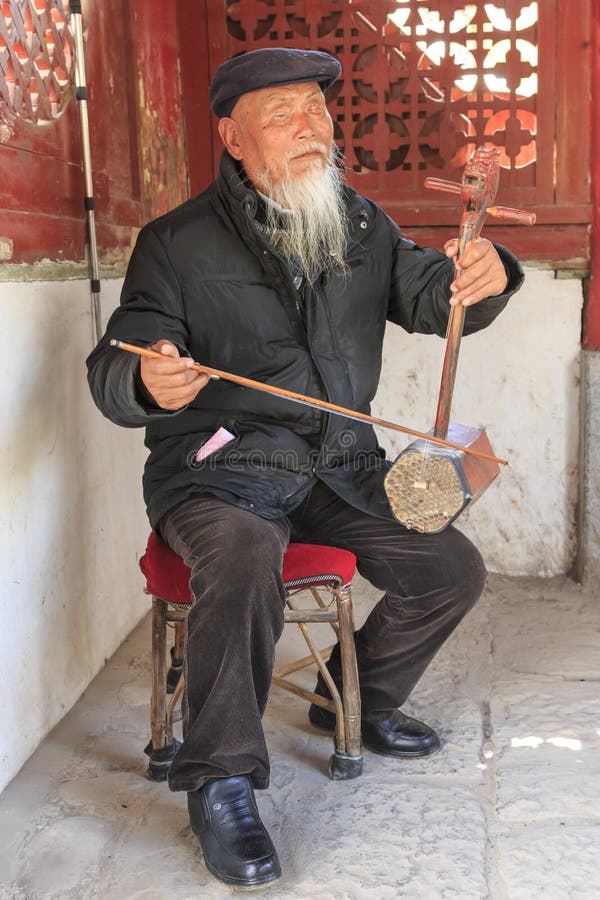Ο τυφλός κινεζικός ηληκιωμένος που παίζει τα αρχαία κινέζικα το όργανο στο χωριό ShiGu στοκ φωτογραφίες με δικαίωμα ελεύθερης χρήσης Ο τυφλός κινεζικός ηληκιωμένος που παίζει τα αρχαία κινέζικα το όργανο στο χωριό ShiGu στοκ φωτογραφίες με δικαίωμα ελεύθερης χρήσης