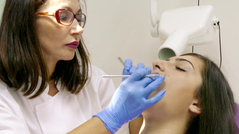Οδοντίατρος στην εργασία στην οδοντική μονάδα με έναν νέο ασθενή γυναικών