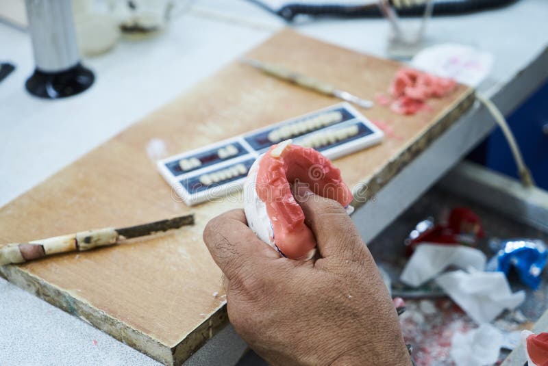 Οδοντικός τεχνικός ή οδοντίατρος που εργάζεται με τις οδοντοστοιχίες δοντιών στοκ εικόνα με δικαίωμα ελεύθερης χρήσης Οδοντικός τεχνικός ή οδοντίατρος που εργάζεται με τις οδοντοστοιχίες δοντιών στοκ εικόνα με δικαίωμα ελεύθερης χρήσης