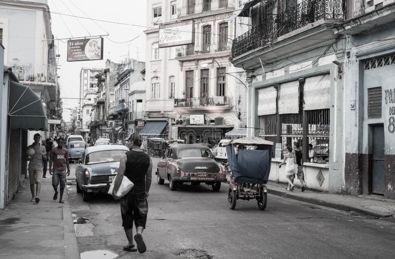 Οδός στην Αβάνα με τους ανθρώπους που περπατούν μπρος πίσω, τα κλασικά αμερικανικά οχήματα και τα παλαιά κτήρια στοκ εικόνα Οδός στην Αβάνα με τους ανθρώπους που περπατούν μπρος πίσω, τα κλασικά αμερικανικά οχήματα και τα παλαιά κτήρια στοκ εικόνα