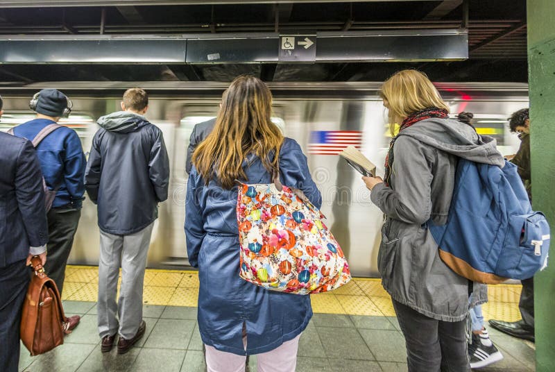 NEW YORK, USA - OCT 21 2015: People wait at subway station times square in New York. With 1.75 billion annual ridership, NYC Subway is the 7th busiest metro system in the world. NEW YORK, USA - OCT 21 2015: People wait at subway station times square in New York. With 1.75 billion annual ridership, NYC Subway is the 7th busiest metro system in the world.