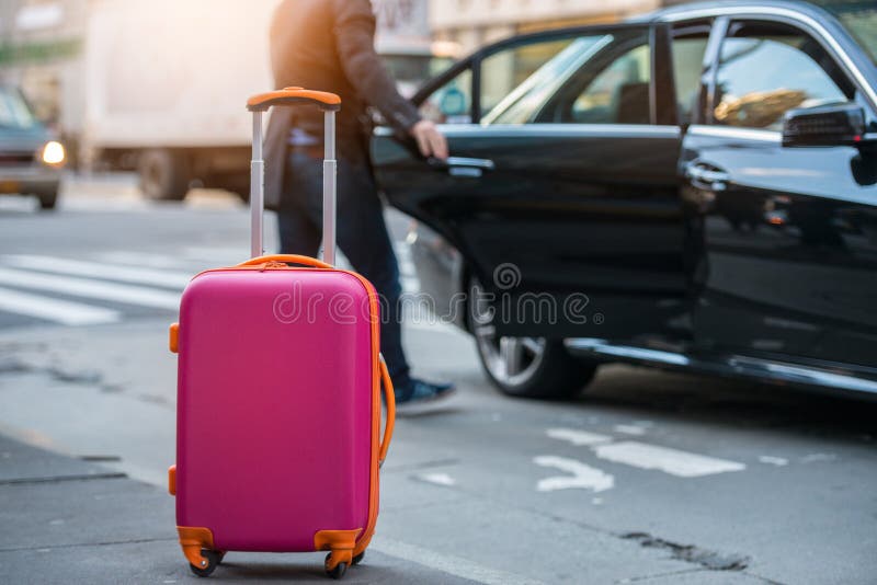 People taking taxi from an airport and loading carry-on luggage bag to the car. Luggage on the city street. Travel concept. People taking taxi from an airport and loading carry-on luggage bag to the car. Luggage on the city street. Travel concept.