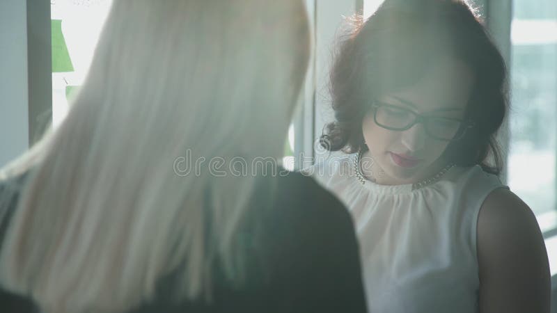 Οι γυναίκες στη στάση γυαλιών και εξετάζουν προσεκτικά τα έγγραφα απόθεμα βίντεο Οι γυναίκες στη στάση γυαλιών και εξετάζουν προσεκτικά τα έγγραφα απόθεμα βίντεο