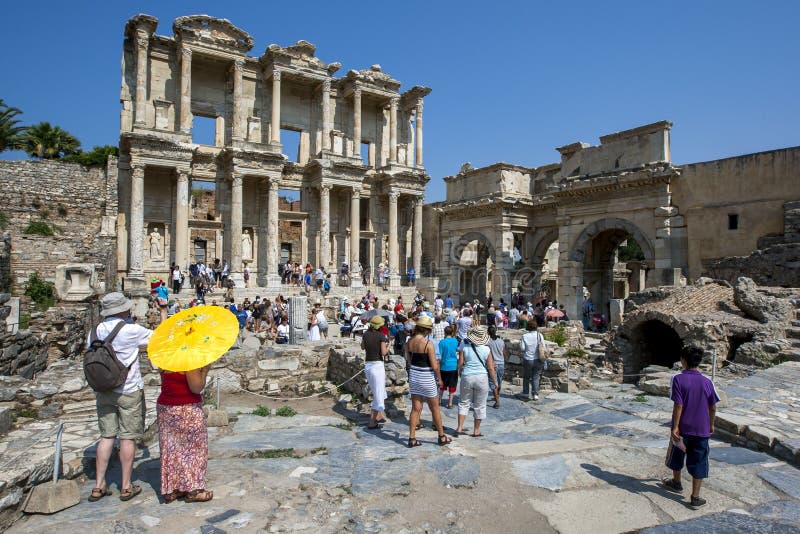 Οι επισκέπτες σε Ephesus κοντά σε Selcuk στην Τουρκία συσσωρεύουν γύρω από τις καταστροφές της βιβλιοθήκης Celcus στοκ εικόνα με δικαίωμα ελεύθερης χρήσης Οι επισκέπτες σε Ephesus κοντά σε Selcuk στην Τουρκία συσσωρεύουν γύρω από τις καταστροφές της βιβλιοθήκης Celcus στοκ εικόνα με δικαίωμα ελεύθερης χρήσης