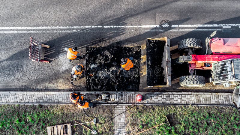 Οι εργαζόμενοι επισκευάζουν την θέα στην κορυφή του δρόμου από το drone στοκ φωτογραφίες Οι εργαζόμενοι επισκευάζουν την θέα στην κορυφή του δρόμου από το drone στοκ φωτογραφίες