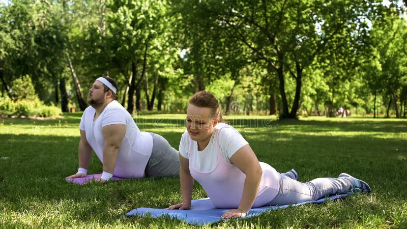 Tired but strong-willed fat people force themselves to do fat-burning routine, stock photo. Tired but strong-willed fat people force themselves to do fat-burning routine, stock photo