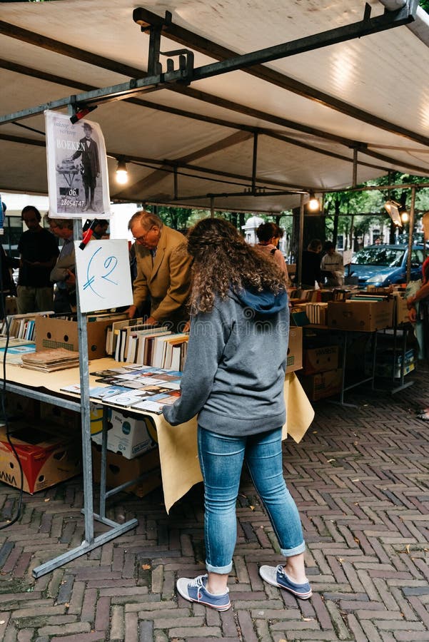 Hague, Netherlands - August 7, 2016: Unidentified people in a book and antiques market stall in the street of The Hague. Hague, Netherlands - August 7, 2016: Unidentified people in a book and antiques market stall in the street of The Hague