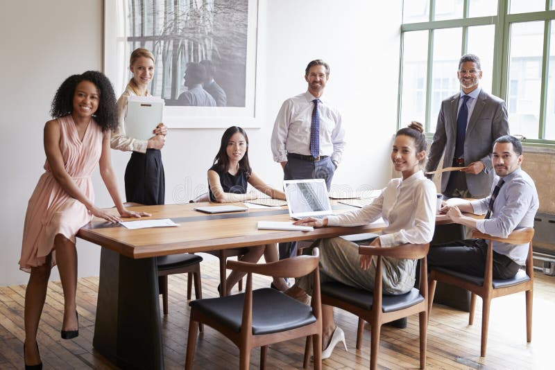 Young professionals at business meeting turn to face camera. Young professionals at business meeting turn to face camera