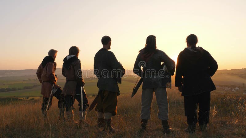 Οι πολεμιστές Βίκινγκ στέκονται στον τομέα και εξετάζουν το όμορφο ηλιοβασίλεμα στον τομέα μάχης