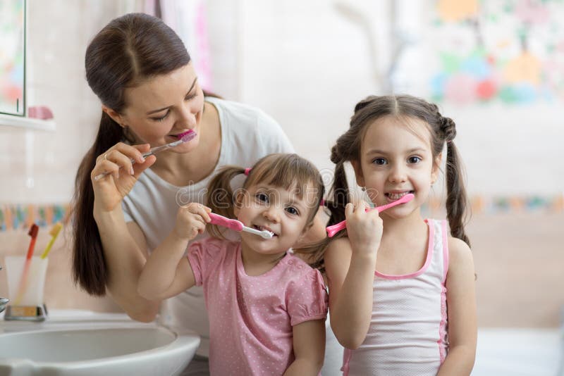 Οικογένεια mom και δύο μικρά κορίτσια βουρτσίζουν τα δόντια τους στοκ φωτογραφίες Οικογένεια mom και δύο μικρά κορίτσια βουρτσίζουν τα δόντια τους στοκ φωτογραφίες