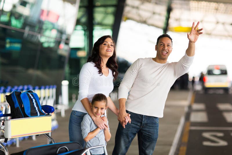 Handsome men and his family hailing taxi at airport. Handsome men and his family hailing taxi at airport