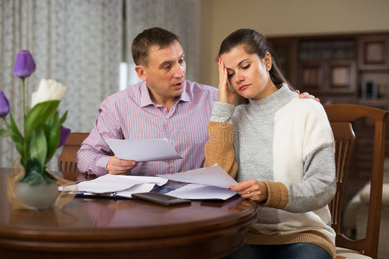 Adult family couple reading mail together and checking accountancy in home interior. Adult family couple reading mail together and checking accountancy in home interior