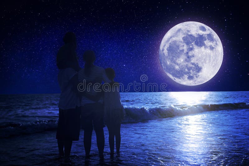 Οικογένεια που στέκεται στην παραλία και παρακολουθεί το φεγγάρι Γιορτή στα μέσα του φθινοπώρου