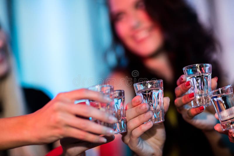 Ομάδα φίλων που ψήνουν πυροβοληθε'ντα τα tequila γυαλιά στοκ εικόνα