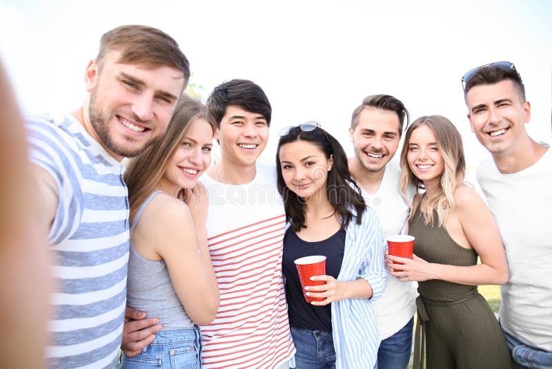Ομάδα ελκυστικών νέων που παίρνουν selfie υπαίθρια στοκ εικόνα Ομάδα ελκυστικών νέων που παίρνουν selfie υπαίθρια στοκ εικόνα