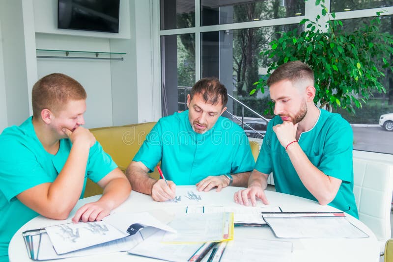 Group of medical staff discussing patient results in clinic. Healthcare professionals having discussion in hospital. Experienced doctor explaining smth and educating medical students. Copy space. Group of medical staff discussing patient results in clinic. Healthcare professionals having discussion in hospital. Experienced doctor explaining smth and educating medical students. Copy space