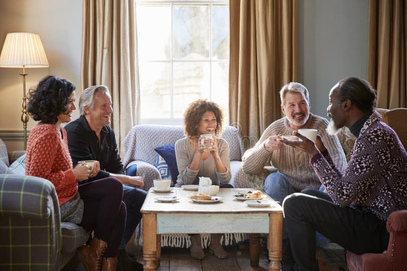 Group Of Middle Aged Friends Meeting Around Table In Coffee Shop. Group Of Middle Aged Friends Meeting Around Table In Coffee Shop