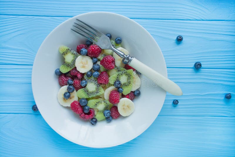 Οπωροφόρα πιάτα Kiwi, μπανάνες, βατόμουρο και φρουτοσαλάτα με βατόμουρο Φόντο ξύλου στοκ φωτογραφίες Οπωροφόρα πιάτα Kiwi, μπανάνες, βατόμουρο και φρουτοσαλάτα με βατόμουρο Φόντο ξύλου στοκ φωτογραφίες