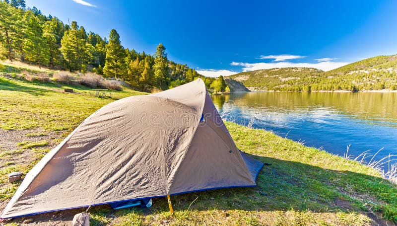 A campers tent set up at Hauser Lake in Montana USA under a sunny blue sky. A campers tent set up at Hauser Lake in Montana USA under a sunny blue sky