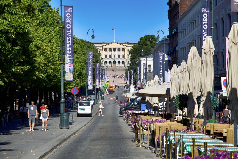 OSLO, NORWAY - AUGUST 17, 2016: People walk Oslo's main street Karl Johans at center with the Royal Palace in the background in Oslo, Norway on August 17, 2016. OSLO, NORWAY - AUGUST 17, 2016: People walk Oslo's main street Karl Johans at center with the Royal Palace in the background in Oslo, Norway on August 17, 2016.