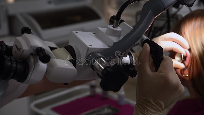 οτολαρυγγολόγος διεξάγει ιατρική εξέταση του αυτιού με το otoscope να κλείνει φιλμ μικρού μήκους