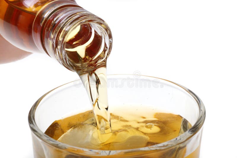 Pouring whisky in a glass on white background. Pouring whisky in a glass on white background.