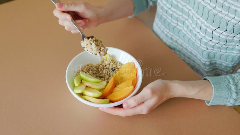 πάνω όψη ωμή βρώμη mango φυσικό μπολ και κουτάλι στα χέρια γυναικών. φιλμ μικρού μήκους