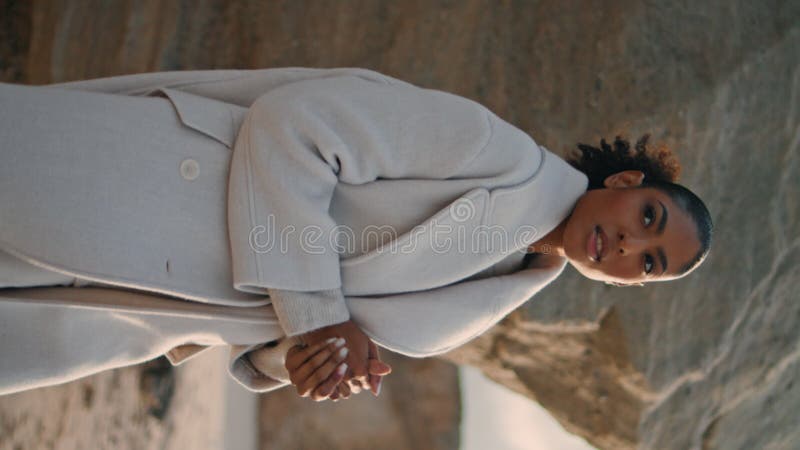 πέναλτι κορίτσι αναπαύεται θαλάσσια πέτρα κάθετα το σαββατοκύριακο. σίγουρη μαύρη γυναίκα