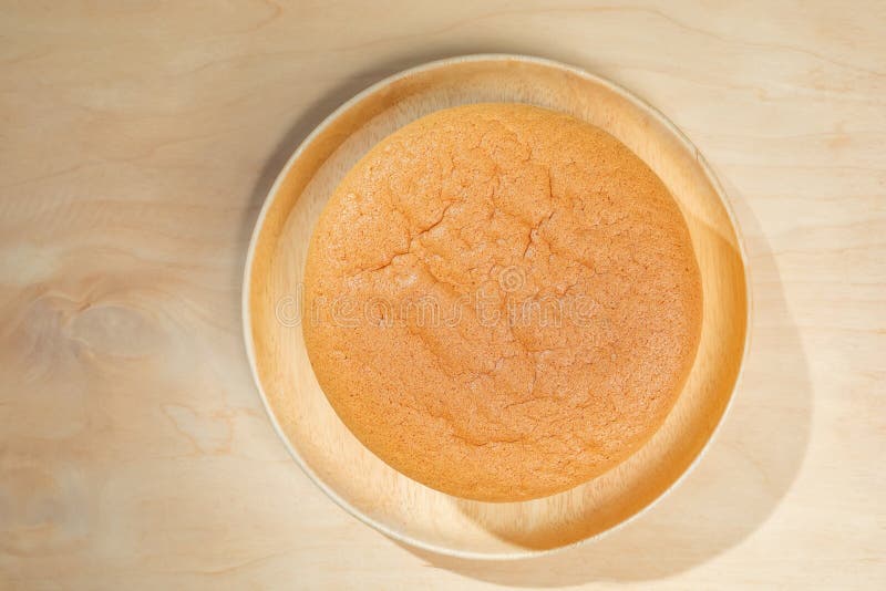 Top view, Plain chiffon or sponge cake on wooden plate on a wooden floor background. Top view, Plain chiffon or sponge cake on wooden plate on a wooden floor background