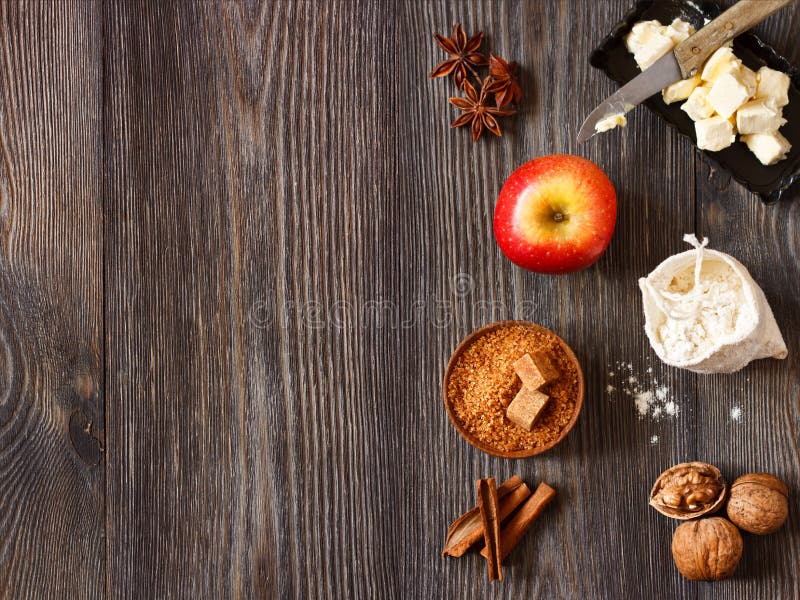 Ingredients for apple pie cooking. Fresh red apple, butter, flour, brown sugar, nuts and spices on a rustic wooden background. Ingredients for apple pie cooking. Fresh red apple, butter, flour, brown sugar, nuts and spices on a rustic wooden background.