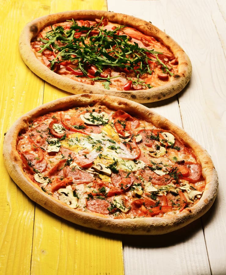 Πίτσα με pepperoni, τα μανιτάρια και το αυγό στο κίτρινο ξύλινο υπόβαθρο στοκ εικόνες Πίτσα με pepperoni, τα μανιτάρια και το αυγό στο κίτρινο ξύλινο υπόβαθρο στοκ εικόνες